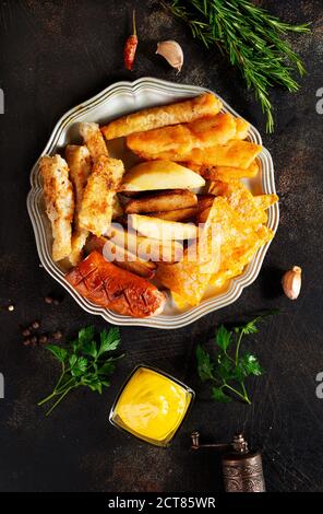 Gebratene Wurst Kartoffel Fisch Filet und Nachos Stockfoto