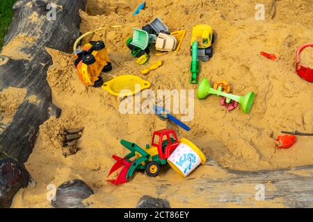 Sandkasten, auf einem Kinderspielplatz, Sandkasten mit verschiedenen Spielzeugen aus Kunststoff, Bagger, Schaufeln, Formen Sauerland, NRW, Deutschland Stockfoto