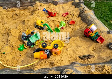 Sandkasten, auf einem Kinderspielplatz, Sandkasten mit verschiedenen Spielzeugen aus Kunststoff, Bagger, Schaufeln, Formen Sauerland, NRW, Deutschland Stockfoto