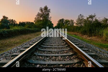 Bahnstrecke in Landschaft mit bunten Himmel und Sonnenuntergang auf Ein schöner Sommerabend Stockfoto