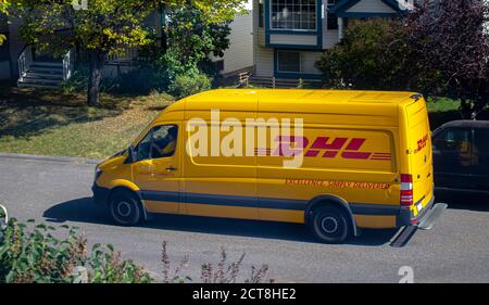 Calgary, Alberta, Kanada. September 21 2020. Ein DHL-Mitarbeiter fährt an einem sonnigen Tag einen Van Stockfoto