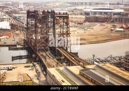 Düstere Aussicht auf die Dock Bridge (Amtrak Dock Vertical Lift) über den Passaic River; Red Bull Arena und NYC Skyline in der Ferne gesehen. Stockfoto