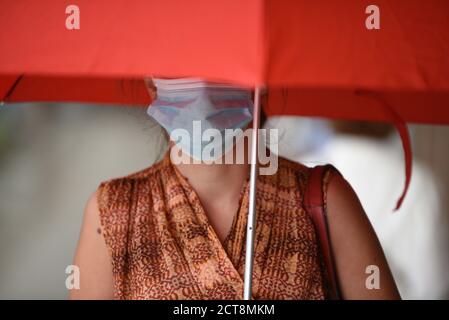 Barcelona, Spanien. September 2020. Eine Frau, die einen Regenschirm als Schutz vor dem Regen trägt, wird als vorbeugende Maßnahme gegen die Ausbreitung des Coronavirus gesehen. Kredit: SOPA Images Limited/Alamy Live Nachrichten Stockfoto