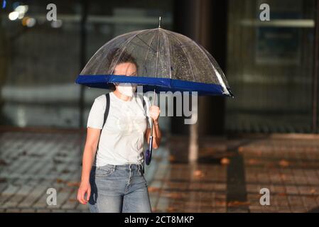 Barcelona, Spanien. September 2020. Eine junge Frau, die einen Regenschirm als Schutz vor dem Regen trägt, wird als vorbeugende Maßnahme gegen die Ausbreitung des Coronavirus angesehen. Kredit: SOPA Images Limited/Alamy Live Nachrichten Stockfoto