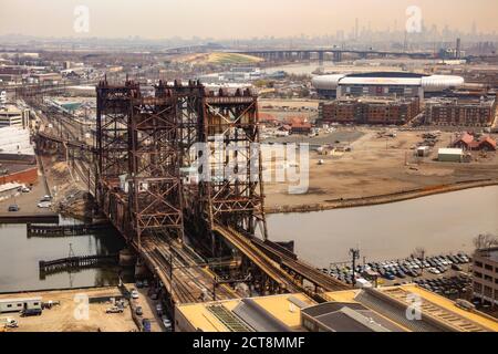 Düstere Aussicht auf die Dock Bridge (Amtrak Dock Vertical Lift) über den Passaic River; Red Bull Arena und NYC Skyline in der Ferne gesehen. Stockfoto