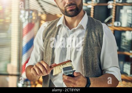 Gut ausgebildetes Barbershop-Personal, das die Haarschneidewerkzeuge sauber hält Stockfoto