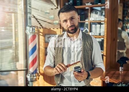 Professioneller Friseur hält seinen elektrischen Haarschneider ordentlich und sauber Stockfoto