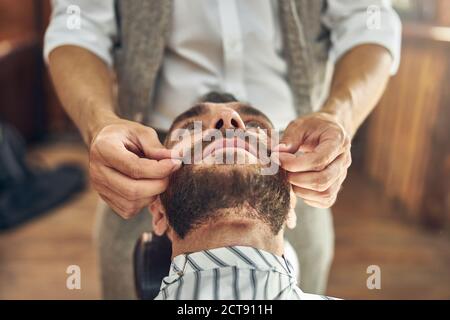 Brunette Mann kippen Kopf nach hinten und mit seinem Schnurrbart gewachst Stockfoto