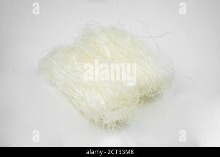 Ungekochte trockene Glasnudel, weiße Bohnen asiatische Vermicelli, Reisnudeln, isoliert auf weiß Stockfoto