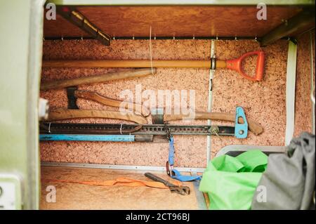 Draufsicht auf Wanderausrüstung auf Holzbalken. Zu den Artikeln gehören Wanderschuhe, Tasse, Seil, Messer, Streichhölzer. Stockfoto