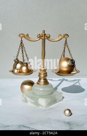 Nahaufnahme der dekorativen Waage aus Gold und Marmor mit Weihnachtskugeln. Stockfoto