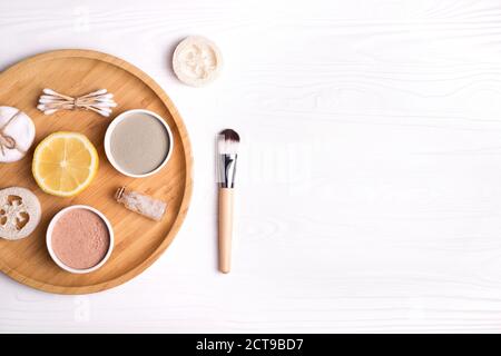 Kosmetische Ton Gesichtsmasken, Meersalz, Zitrone und Pinsel auf Holz Hintergrund. Stockfoto