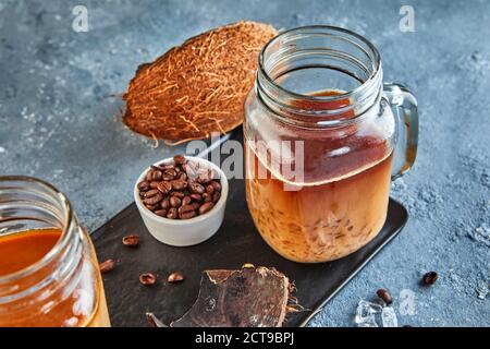 Thailändischer Eiskaffee mit Kokosmilch mit zerkleinertem Eis in einem Mason-Glas. Stockfoto