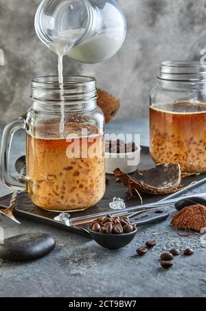 Thailändischer Eiskaffee mit Kokosmilch mit zerkleinertem Eis in einem Mason-Glas. Stockfoto