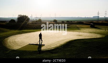 Laatzen, Deutschland. September 2020. Ein Greenkeeper entfernt den Morgentau auf einem Grün auf dem Golfplatz Gleidingen in der Region Hannover. Kredit: Julian Stratenschulte/dpa/Alamy Live Nachrichten Stockfoto