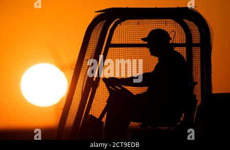 Laatzen, Deutschland. September 2020. Ein Greenkeeper fährt über den Golfplatz Gleidingen in der Region Hannover, wenn die Sonne am Horizont aufgeht. Kredit: Julian Stratenschulte/dpa/Alamy Live Nachrichten Stockfoto