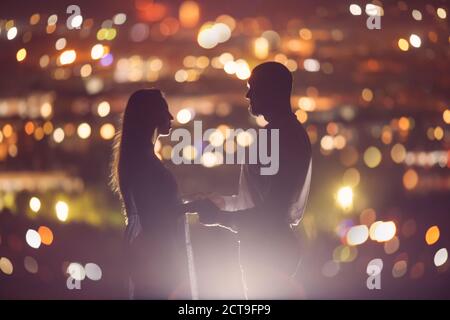 Liebhaber Mann und Mädchen vor Hintergrund Nacht Stadt, Himmel und Horizont. Konzept Datum Valentinstag, ersten Kuss Liebe Stockfoto