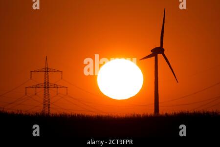 Laatzen, Deutschland. September 2020. Die Silhouette einer Windmühle (r) hebt sich von der aufgehenden Sonne ab. Kredit: Julian Stratenschulte/dpa/Alamy Live Nachrichten Stockfoto