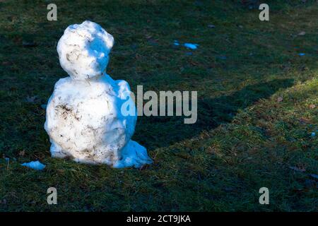 Deutschland, Reste der Schneemann auf der Wiese Stockfoto