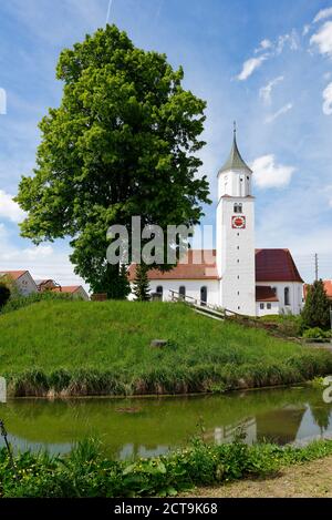 Deutschland, Bayern, Dietmannsried, Blick auf die Pfarrkirche St. Blasius und Quirinus mit Wassergraben im Vordergrund Stockfoto