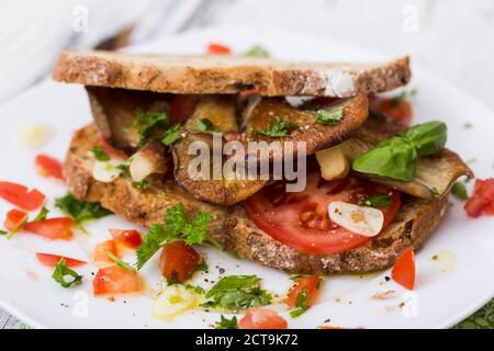 Brotscheiben mit gebratenen Oystermuhrooms und Tomaten Stockfoto