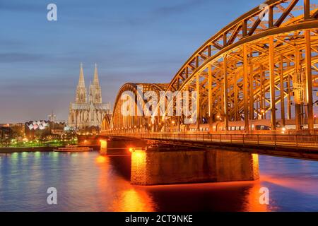 Deutschland, Nordrhein-Westfalen, Köln, Blick auf beleuchtete Hohenzollernbrücke und Kölner Dom am Abend Stockfoto