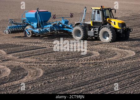 Deutschland, Bayern, Traktor mit Scheibenegge auf gepflügten Boden Stockfoto