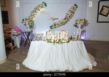 Tischset für Event-Party oder weiße Blumen Hochzeitsempfang. Hochzeitsbankett im Restaurant, Tische mit Blumen und Dekorationen, Kerzen. Stockfoto