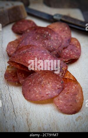 Salami in Scheiben geschnitten auf Holztisch Stockfoto