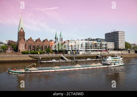 Deutschland, Bremen, Blick auf St. Martins Kirche und Martini Pier mit Frachtschiff vor Landung Stockfoto