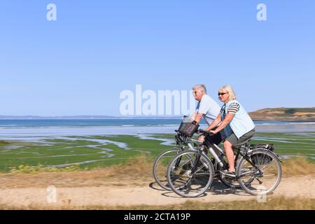 Frankreich, Bretagne, Finistere, Senior paar auf e-Bikes an der Küste Stockfoto