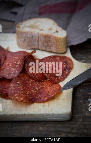 Salami in Scheiben geschnitten auf Holztisch Stockfoto