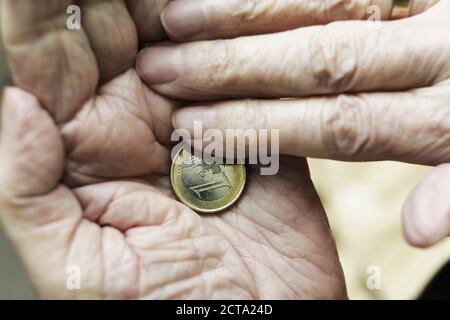 Deutschland, Nordrhein-Westfalen, Köln, Senior Woman Holding ein-Euro-Münze, Nahaufnahme Stockfoto