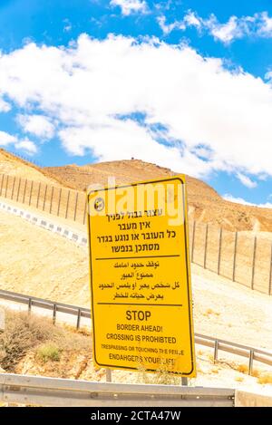 Route 10 entlang der ägyptisch-israelischen Grenze. Blick in Ägypten aus Israel Gelbe Grenze voraus Warnschild in Hebräisch Arabisch und Englisch Stockfoto