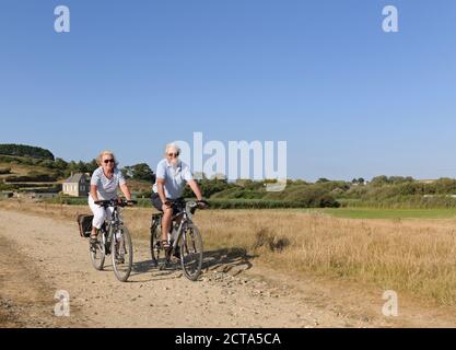 Frankreich, Bretagne, Finistere, Senior paar auf e-Bikes an der Küste Stockfoto