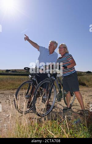 Frankreich, Bretagne, Finistere, Senior paar auf e-Bikes an der Küste Stockfoto