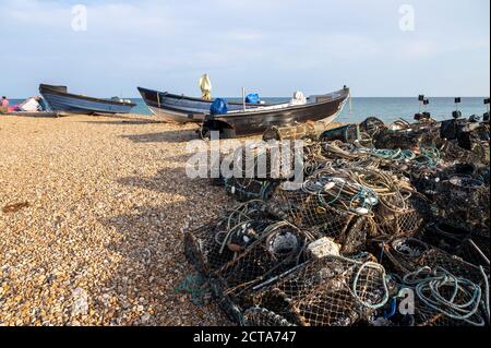Lokale Fischerboote am Strand umgeben von Angelausrüstung, Hummertöpfen, Netzen und Seil. Stockfoto