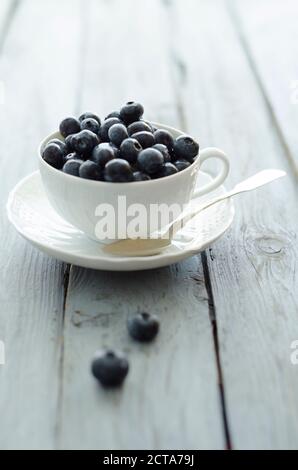Tasse Heidelbeeren auf Holztisch, Nahaufnahme Stockfoto