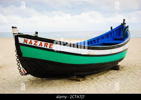 Traditionelles buntes Boot am Strand von Nazare (Portugal) Stockfoto