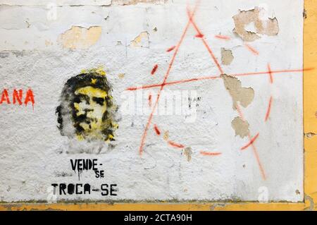 TOMAR, PORTUGAL - 28. APRIL 2015: Graffiti von Che Guevara auf der alten Hauswand, Text in Portugiesisch „zum Verkauf, zum Austausch“ und Anarchie-Symbol. Stockfoto