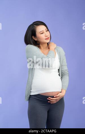 Asiatische schwangere Frauen haben Nackenschmerzen. Gesundheit und Krankheit Konzept. Schulterschmerzen Stockfoto