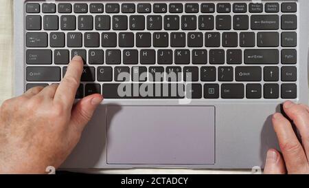 Nahaufnahme von Tastatur und Händen einer älteren Frau Tippen auf einem Laptop Draufsicht Stockfoto