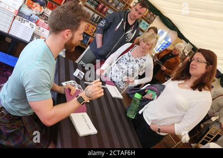 Boswell Book Festival, Dumfries House, Cumnock Ayrshire, Schottland, Großbritannien 12. Mai 2018. Autor Finlay Wilson diskutiert sein Buch Kilted Yoga, hier gesehen Signing sein Buch das jährliche Boswell Book Festival ist einzigartig, da es das einzige Book Festival ist, das sich exculsiv mit Memoiren und Biographien auseinandersetzt. Stockfoto