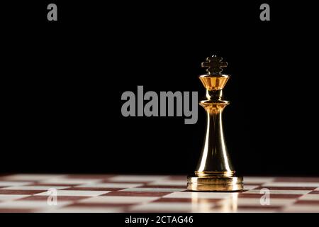 Goldene König Schachfigur auf Schachbrett Stockfoto