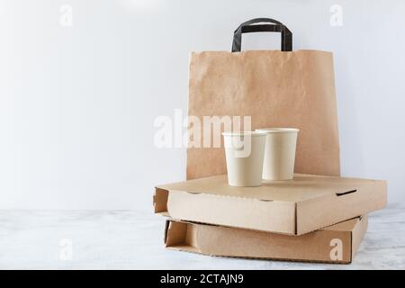 Verschiedene Take-out Food Einweg-Container, Pizza-Box, Kaffeetassen und Papierbeutel auf weißem Hintergrund. Lieferservice. Stockfoto