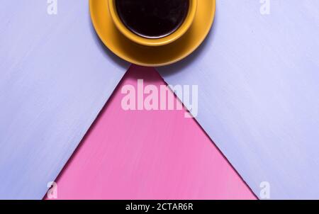 Heißer schwarzer aromatischer Kaffee americano auf einem alten rosafarbenen Holztisch mit Herbstblättern. Heißer Kaffee. Stockfoto
