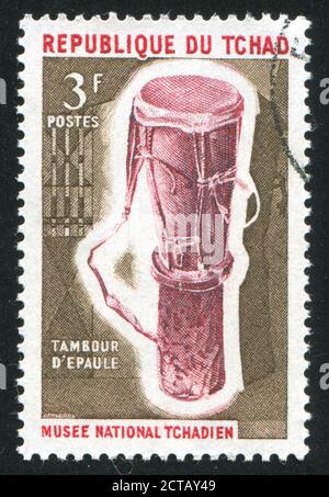 TSCHAD - UM 1965: Briefmarke gedruckt von Tschad, zeigt Schultertrommeln, um 1965 Stockfoto