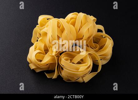 Rohe fettuccine Pasta isoliert auf schwarzem Hintergrund Stockfoto