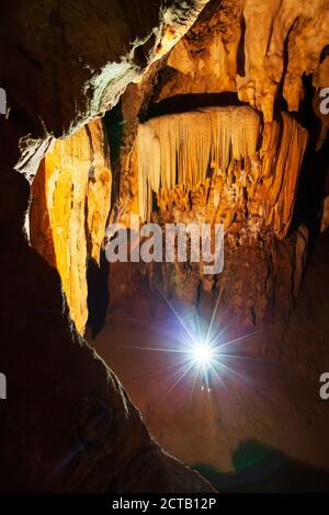 Erkunden mystische Kalksteinhöhle mit Fackel, magische Form und Textur von Stalaktiten und Stalagmiten in der großen Höhle. Nam Nao, Thailand. Stockfoto