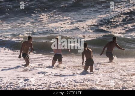 Junge männliche Urlauber verbringen ihren Urlaub am Fistral Beach in Newquay in Cornwall. Stockfoto